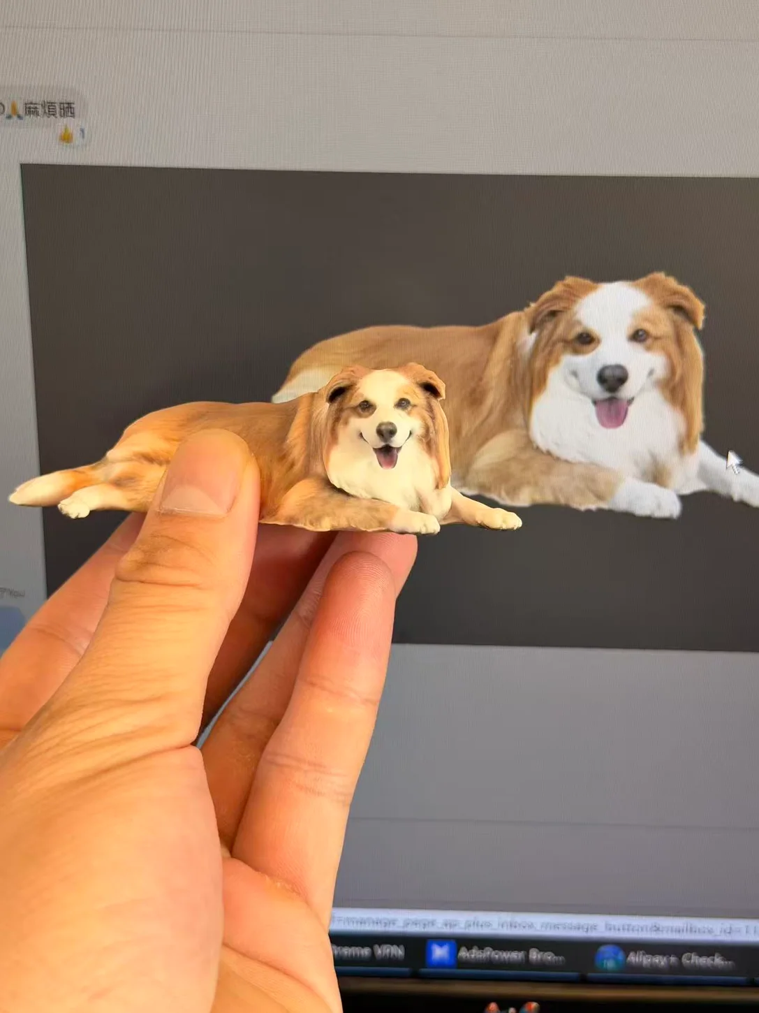 Handheld long-haired dog figurine in front of its reference photo