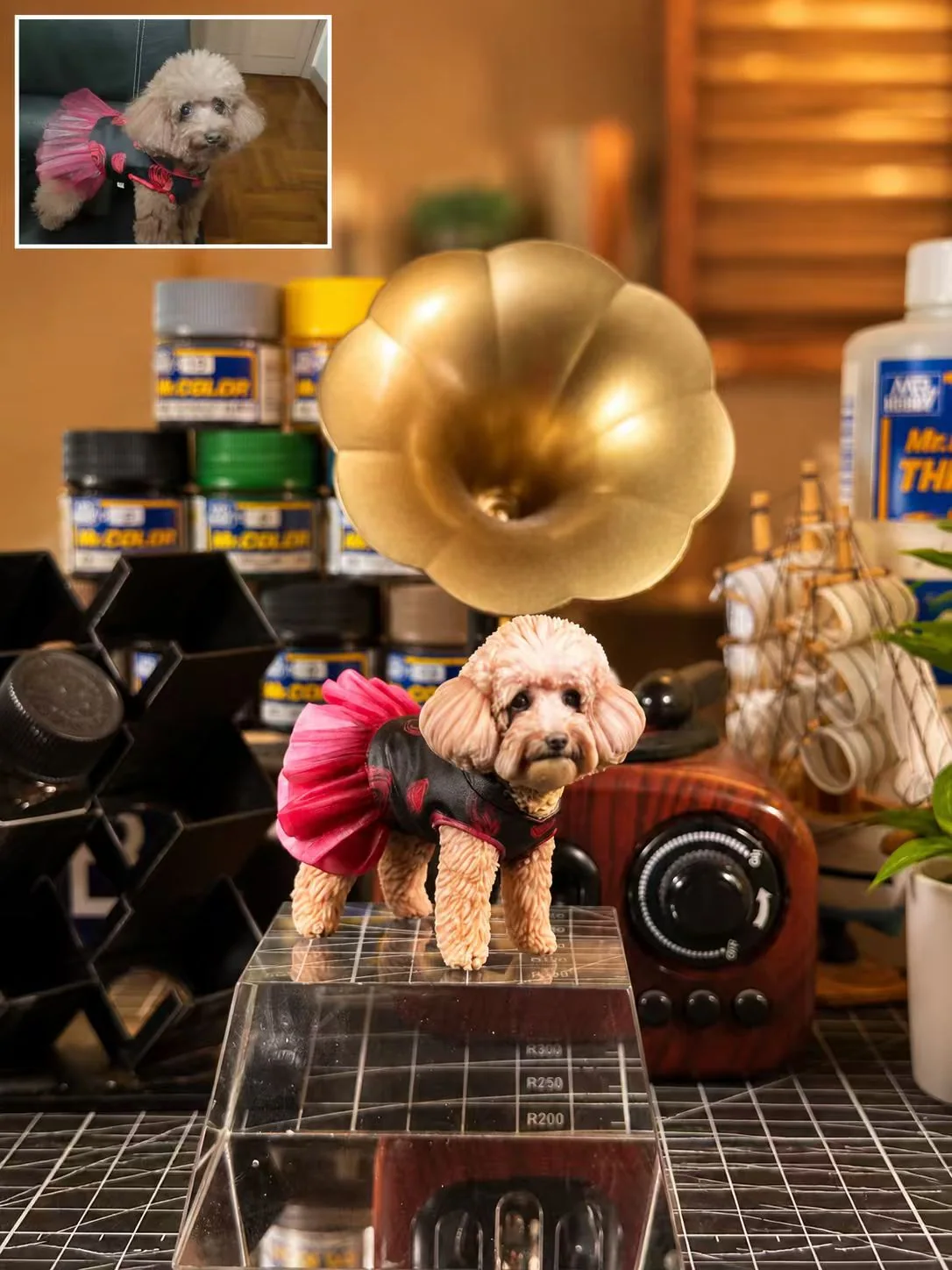 Poodle figurine in a pink and black outfit with an inset reference photo