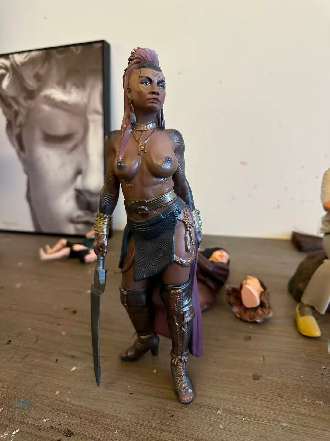 Finished fantasy warrior art sculpture with sword and detailed costume, photographed in the studio