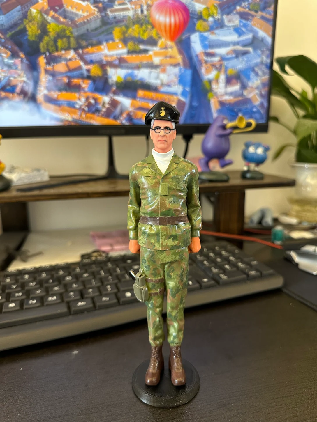 Finished portrait figurine wearing camouflage uniform, glasses and a dark beret