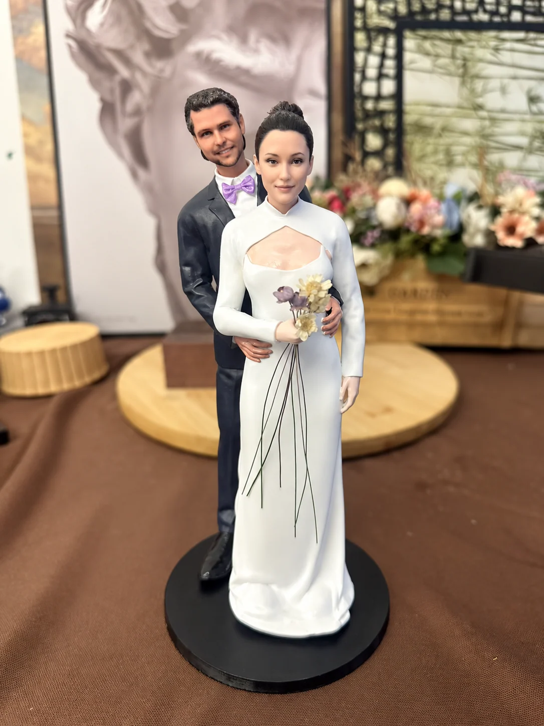 Finished wedding couple figurine with bouquet on a black base, photographed in the studio